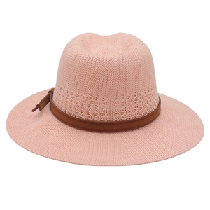 Detail of pink woven straw hat with breathable texture and brown leather decorative band