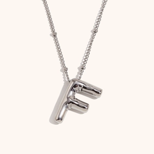 Macro detail of silver 18K plated stainless steel necklace with 3D puffy initial F pendant