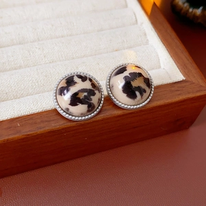 Gros plan de boucles d'oreilles rondes à motif léopard dans un écrin de luxe