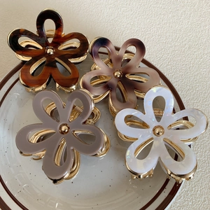 Floral acetate hair claw clip with gold metal spring shown in four elegant colors