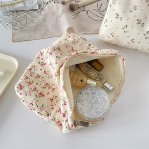 Detailed top view of a floral canvas makeup bag with soft red flowers and zip closure