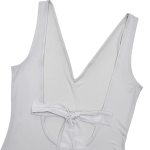 Detail of white one-piece swimsuit with open back design and delicate bow tie detail