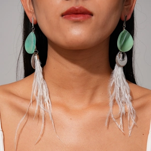 Bohemian earrings with white feathers and green teardrop resin on a female model