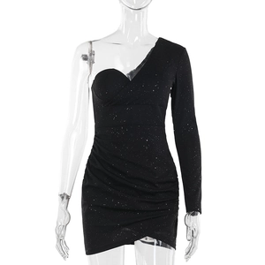 Detalle de vestido negro de lentejuelas con manga asimétrica y textura de tela fruncida