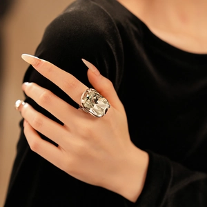 Macro view of geometric cocktail ring featuring a large faceted champagne crystal stone