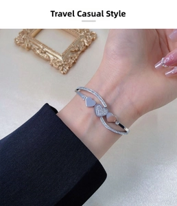 Detail of silver heart-shaped cuff bracelet featuring micro-pave crystals and polished finish