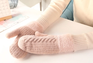 Detailed cable knit pattern on pink winter mittens with soft faux fur cuff decoration