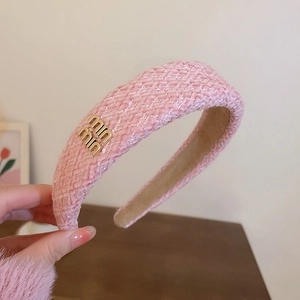 Rosa Stirnband aus Tweed mit Hahnentrittmuster und einem eleganten goldenen Metalllogo