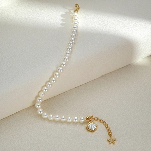 Elegant s925 silver pearl bracelet with starfish and shell charms on beige background