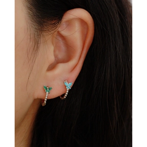 Close-up of vintage s925 silver butterfly earrings with green and blue crystals