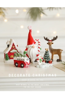 Détail de miniatures de Noël en résine peintes à la main : gnome, renne et maison du Père Noël