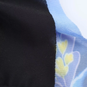 Close-up of black knit fabric joined with yellow floral print blue mesh material