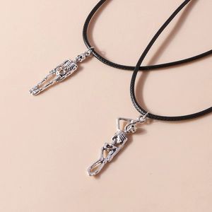Detail of silver skeleton pendants on black cord necklaces for Halloween jewelry styling