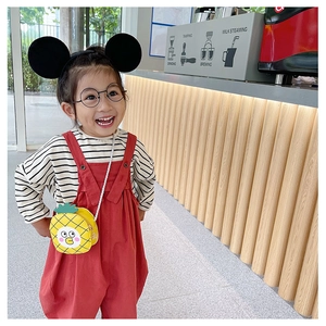 Girl wearing casual red overalls and a cute pineapple shape crossbody shoulder bag