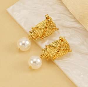 Close-up of textured 18K gold-plated earrings with elegant round white pearls