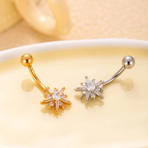 Detailed close-up of gold and silver belly rings with star-shaped cubic zirconia stones