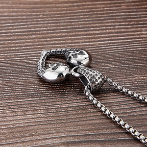 Vue macro du pendentif cœur en acier titane argenté vintage avec double crâne