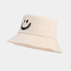 Detail of beige cotton bucket hat featuring a black smiley face print for casual wear