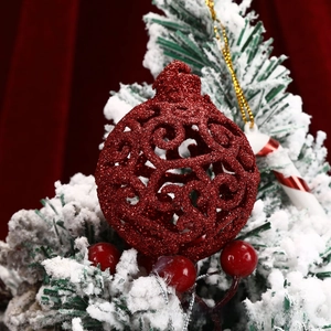 Close-up of a red glitter hollowed-out Christmas ball ornament with gold string