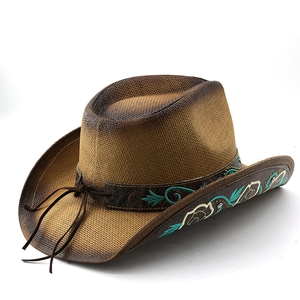Detail of woven straw cowboy hat featuring brown leather band with floral embroidery