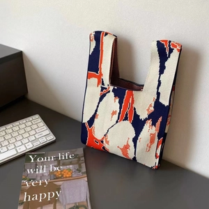 Large capacity knitted tote bag with blue orange floral pattern on a desk