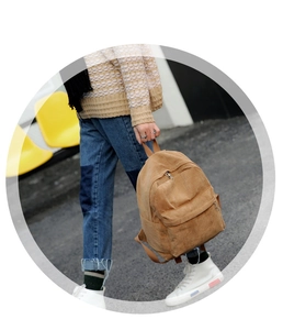Detail view of camel corduroy backpack texture and sturdy top handle in outdoor setting