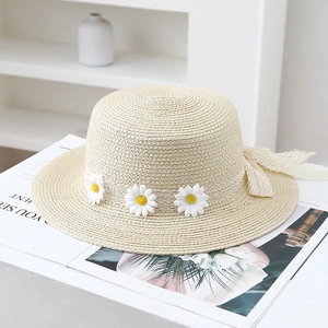 Detail of summer straw hat featuring delicate white lace ribbon and 3D daisy flower accents