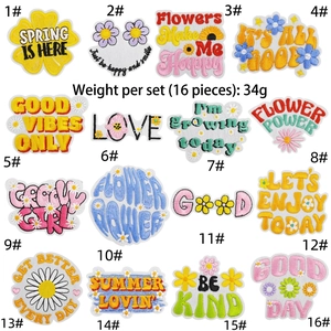 Close-up detail showing 16 colorful hippie floral embroidery patches for laptop and bags