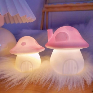 Creative pink mushroom night lights glowing on a soft white plush mat for bedroom decor