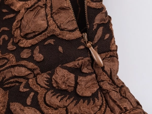 Détail de la fermeture éclair invisible et du motif floral gaufré de la robe longue vintage