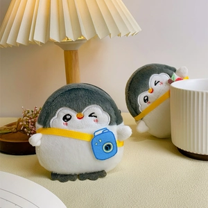 Close-up of grey plush penguin coin purse with embroidered camera bag detail