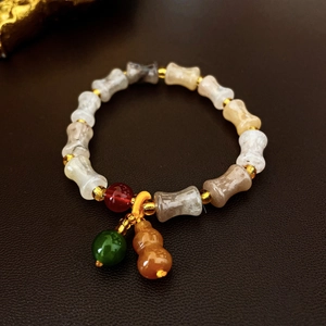 Detailed macro view of neo-Chinese ceramic beaded bracelet with a jade gourd charm