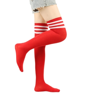 Detail of red over-knee socks with white triple stripes on a model's leg
