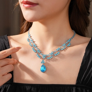 Gros plan d'un collier vintage en argent avec pendentif en cristal bleu taille poire