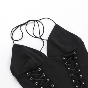 Détail du haut dos nu noir avec œillets métalliques et lacets croisés sur le devant