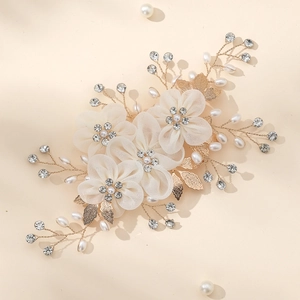 Detail of bridal hair comb with handmade fabric flowers, pearls and golden leaves