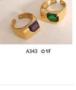 Detail of gold-plated adjustable rings with large rectangular purple and green stones