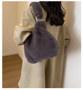 Detail of dark grey faux fur tote bag featuring elegant golden metal ring handles