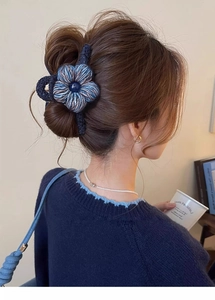 Détail d'une pince à cheveux fleur en laine bleue tissée à la main sur le mannequin