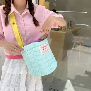 Détail du sac seau matelassé violet avec bandoulière contrastée et poignées colorées