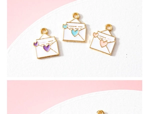 Detailed view of colorful enamel heart envelope pendants for DIY jewelry making