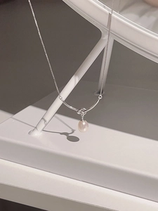 Detail of s925 silver knot necklace featuring a lustrous teardrop freshwater pearl pendant