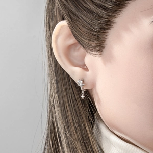 Minimalist silver star pendant hoop earrings featuring dual star design and metallic luster