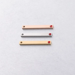 Gedetailleerd beeld van metalen staafhangers in roségoud, zilver en goud met steentjes