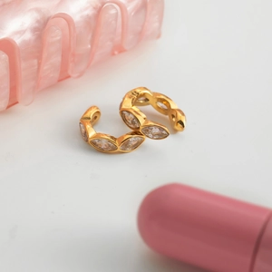 Dettaglio di ear cuff dorati con zirconi taglio marquise in una montatura elegante