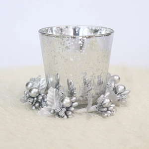 Detail of silver mercury glass candle holder with matching berry and leaf wreath ornament