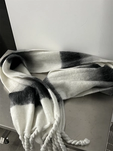 Close-up of thick gradient black and white striped scarf with soft fringe tassels