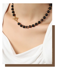 Close-up of natural black agate beaded necklace with gold OT toggle clasp on a model