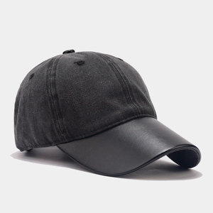 Detail of gray washed canvas cap with a black leather visor and vintage textures
