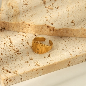 Detail of gold hammered textured ring with embedded zircon on a minimalist stone base